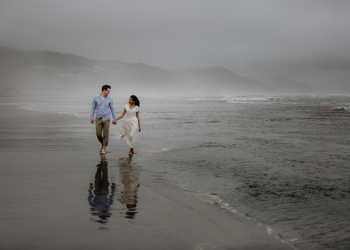Couple strolling at Auckland Beach,