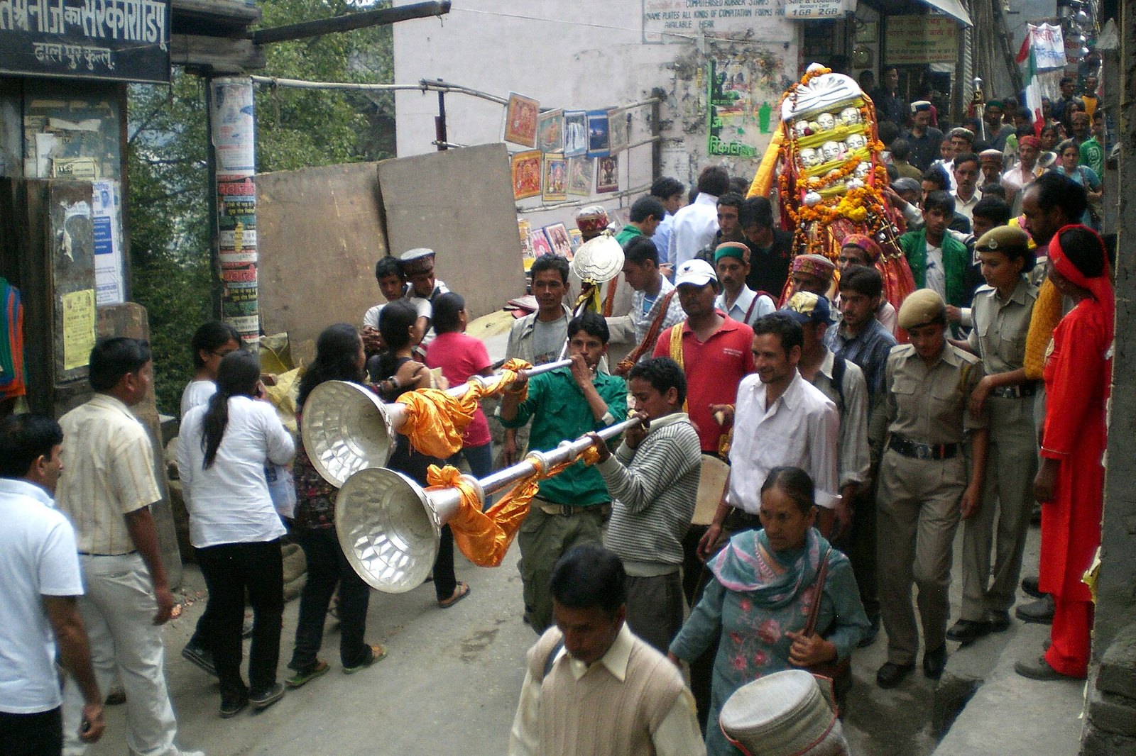 Village devta palanquin and karnal trumpet players walking through Kullu bazaar