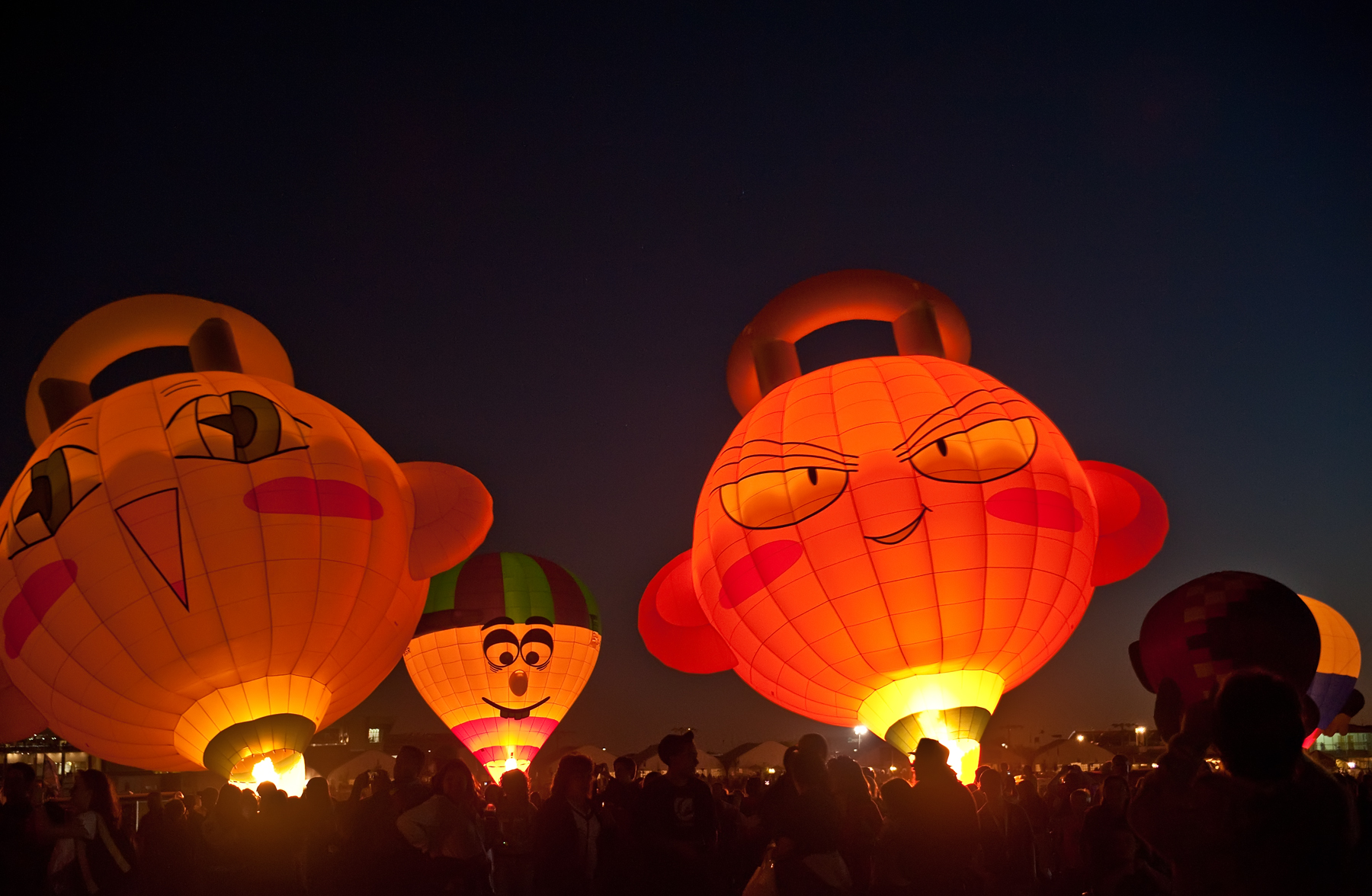 Special Shape Glowdeo balloons lit up at night at Balloon Fiesta Park