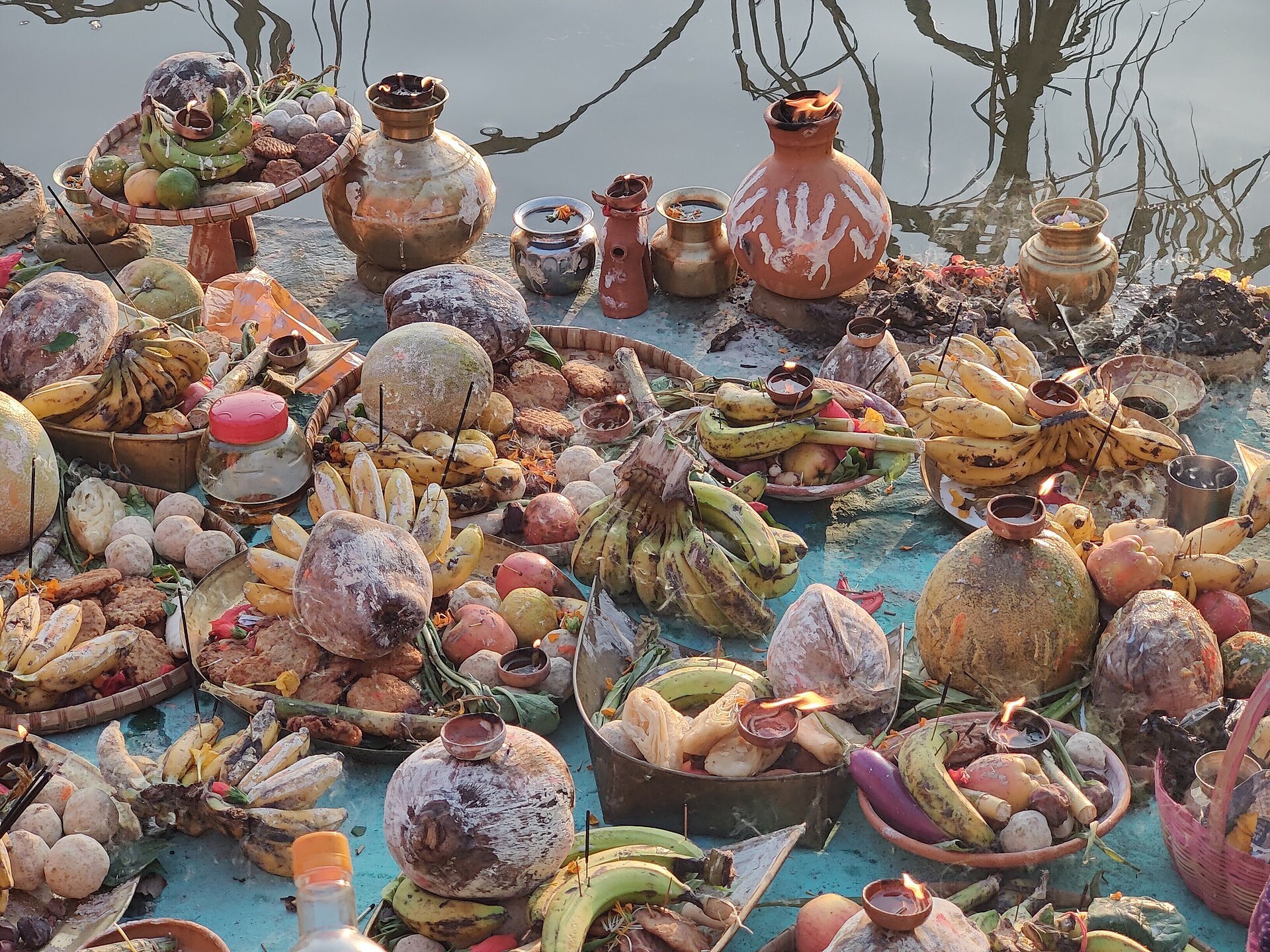 Chhath Puja soop baskets with fruit, thekua and earthen pots lined up on the ghat
