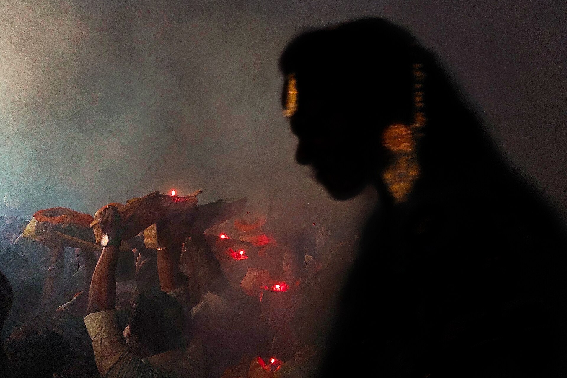 Silhouette of a vrati raising a soop for the Usha Arghya at dawn during Chhath Puja
