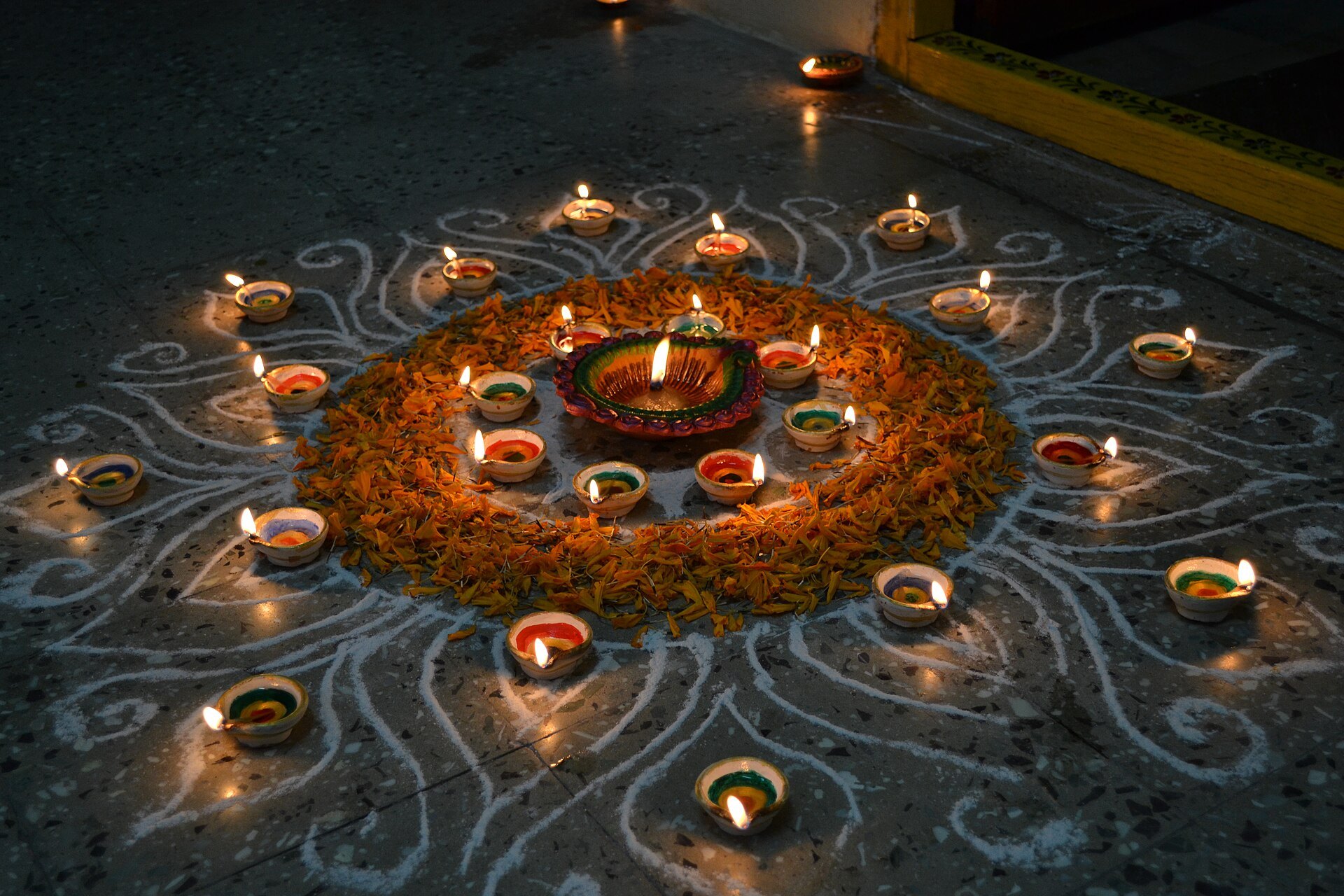 Diwali rangoli with painted diyas and marigold petals