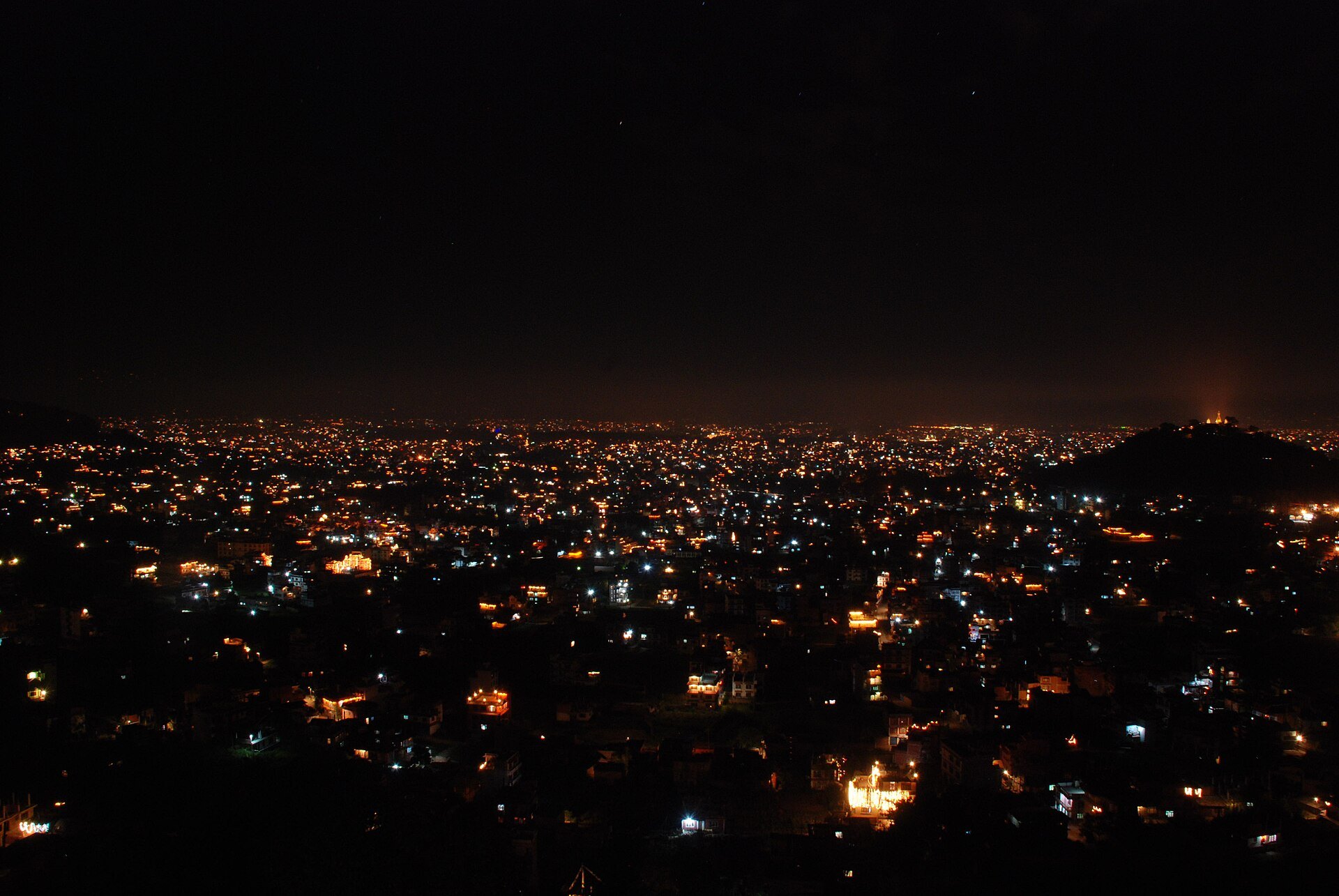 Kathmandu valley lit up at night during Tihar, with Swayambhu hill on the right