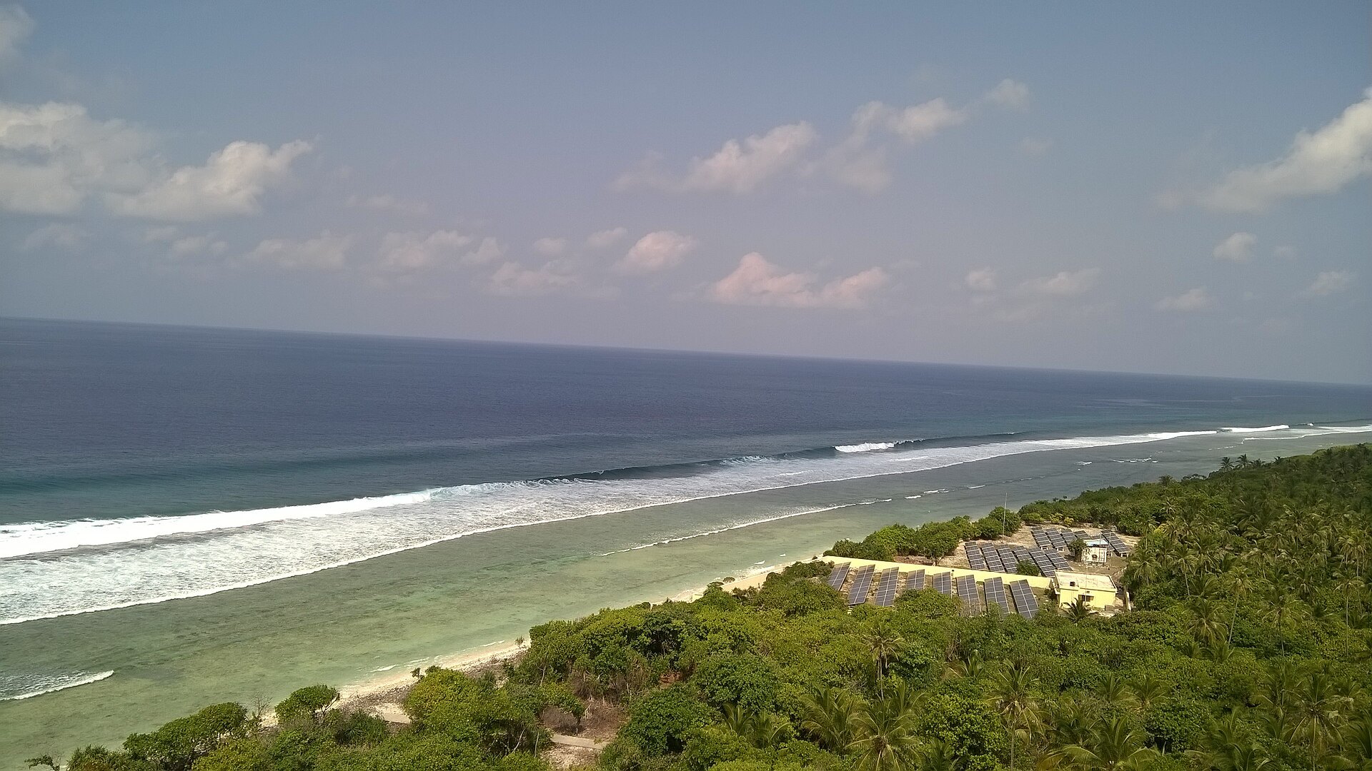 Reef and coconut-covered coastline of Minicoy Island, Lakshadweep, seen from above
