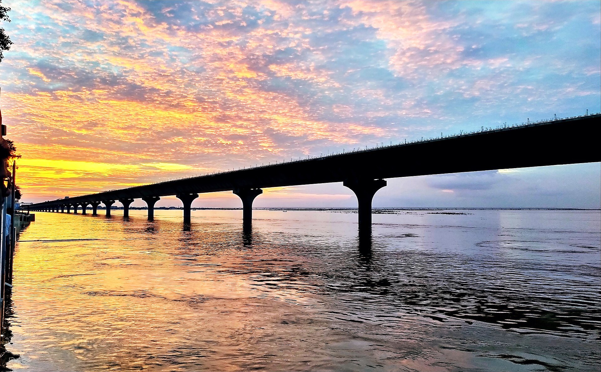 Sunset over the Ganga at a Patna ghat with the JP Setu bridge, where Chhath Puja arghya is offered