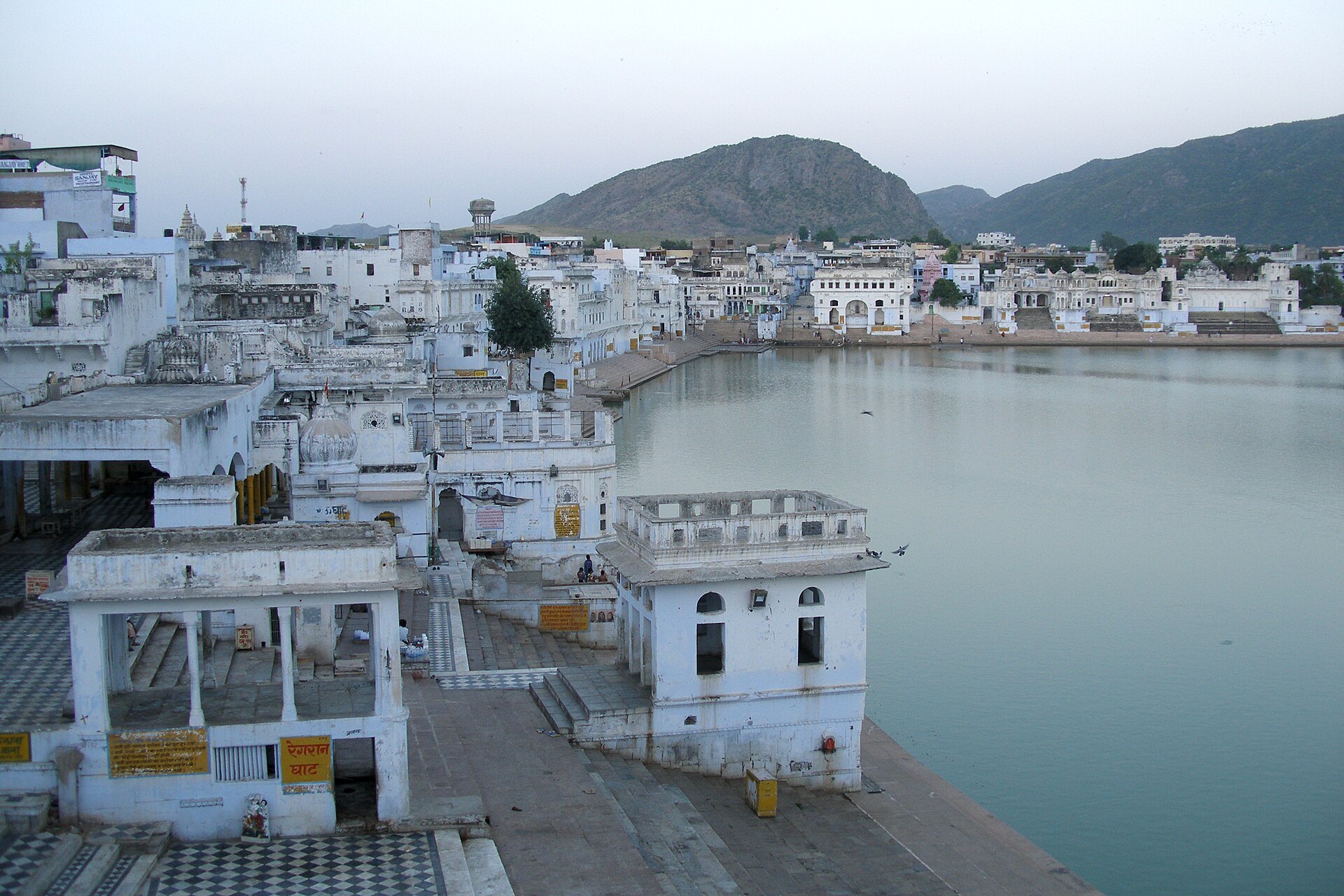 Pushkar Lake and its whitewashed ghats at twilight, where pilgrims bathe on Kartik Purnima