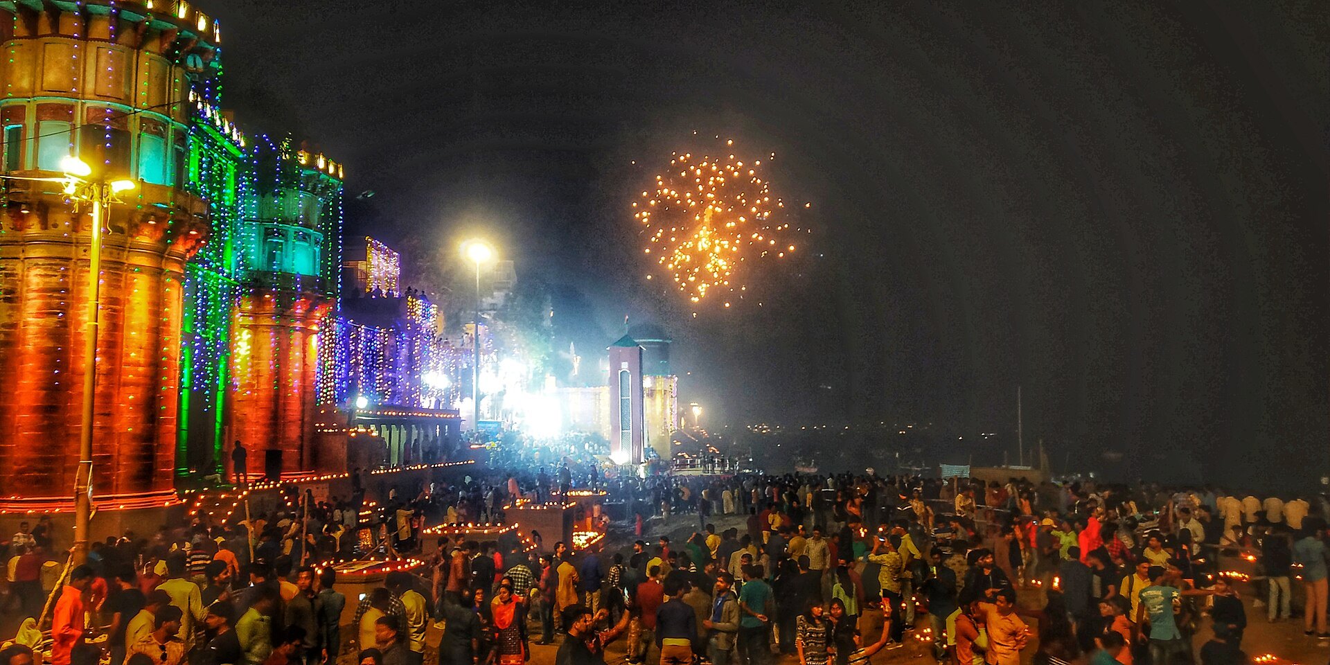 Crowded Varanasi ghats with lamps and fireworks on Dev Deepawali night